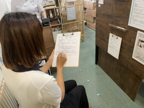受付で問診票に記入してるところ。