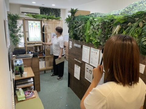 片目を手で覆い、スタッフが示す視力表を読み上げて視力チェックしてるところ